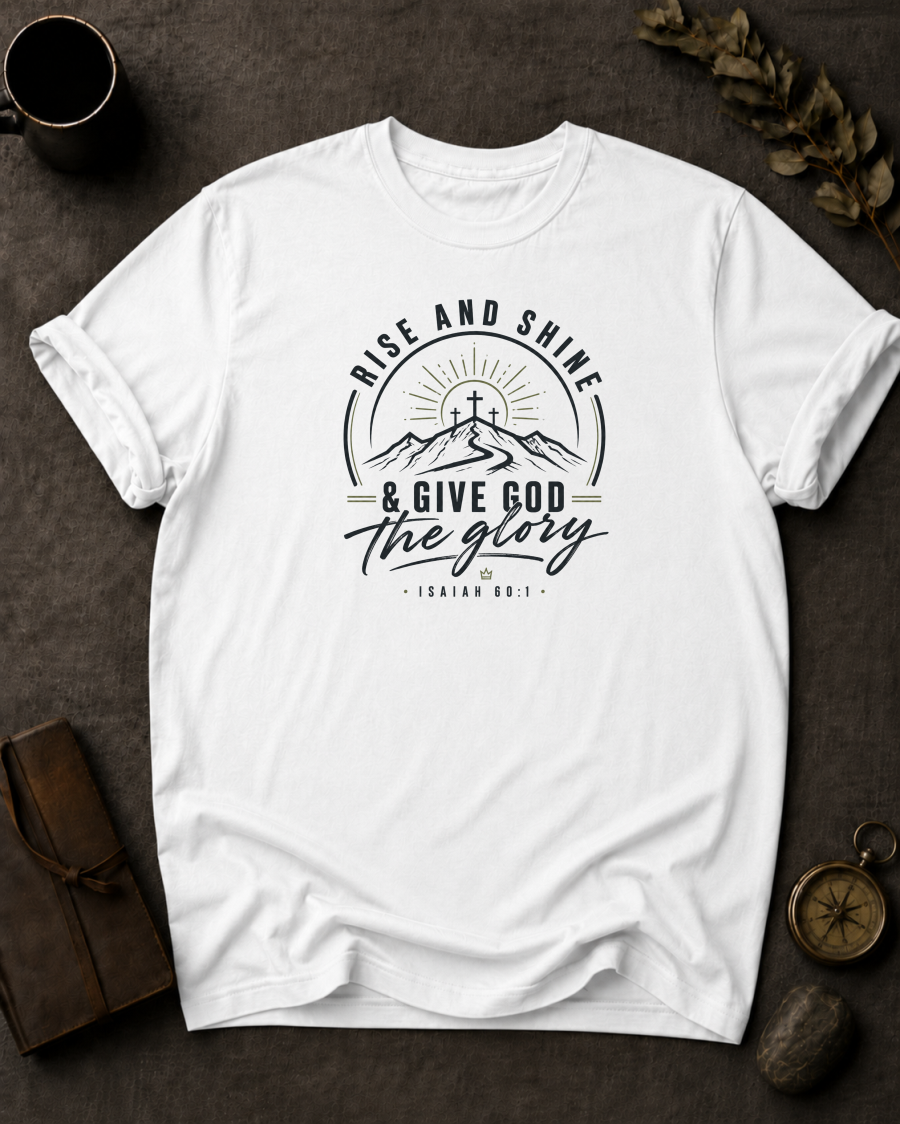 white Comfort Colors t-shirt with "Rise and Shine & Give God the Glory" Isaiah 60:1 mountain sunrise cross design in Bay colorway, styled with coffee mug, compass, and leather journal