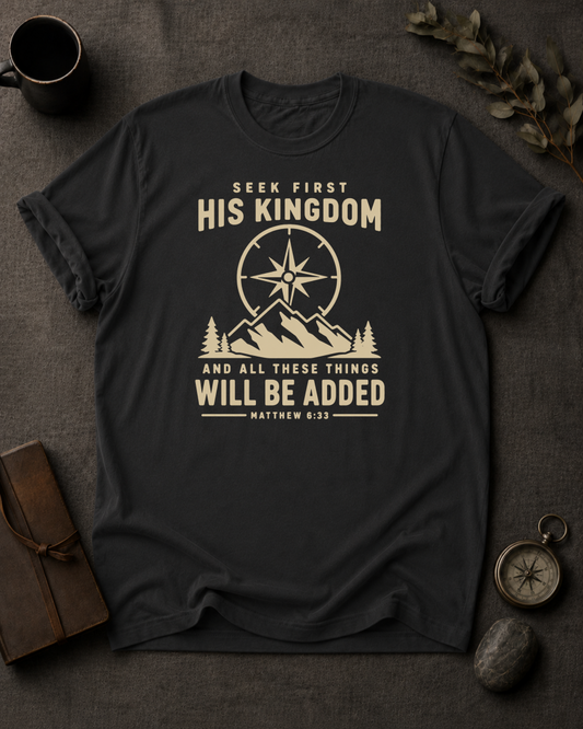 black Comfort Colors t-shirt with compass and mountain design reading 'Seek First His Kingdom, and all these things will be added, Matthew 6:33'"