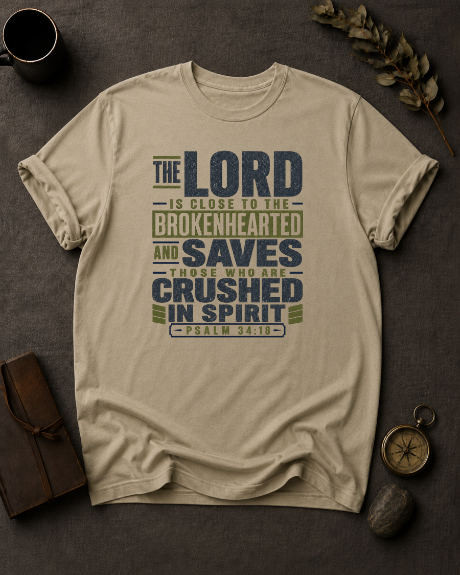sandstone Comfort Colors t-shirt with navy and olive Psalm 34:18 typography design — 'The Lord is close to the brokenhearted'"